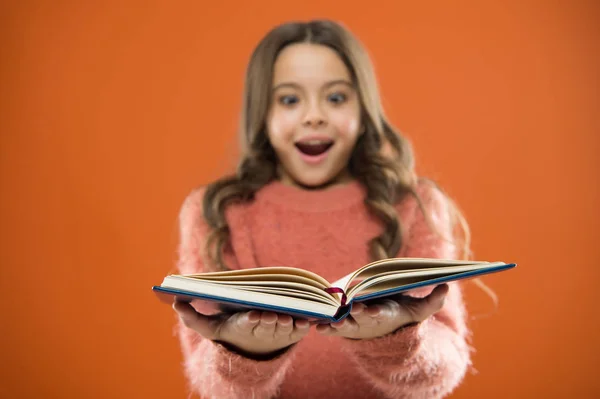 Dítě si číst knihu. Kniha koncept store. Skvělé bezplatné dětské knihy k dispozici ke čtení. Dětská literatura. Užitečné informace pro ni. Dívka drží knihu přečíst příběh oranžové pozadí — Stock fotografie