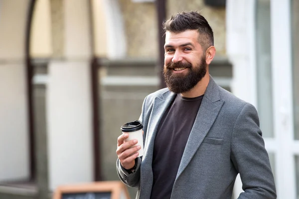 Drink het onderweg op. Man bebaarde hipster liever koffie afhalen. Zakenman drinkt buiten koffie. Herladen van energie. Ontspannende koffiepauze. Hipster houdt papieren koffiebeker vast en geniet van de stedelijke omgeving — Stockfoto