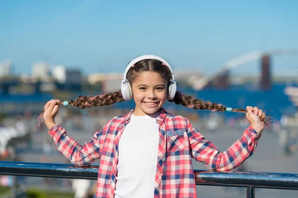 Girl child listen music outdoors with modern headphones. Listen for free. Get music family subscription. Access to millions of songs. Enjoy music everywhere. Best music apps that deserve a listen
