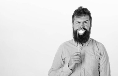 Duygusal uyumsuzluk kavramı. Adam holding parti gülümseyen dudakları onun yüz ciddi, beyaz arka planı sahne. Hipster sakal ve bıyık sıkı yüzündeki mutlu ile poz ile ağız, gülümseyen kopyalama alanı