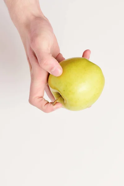 Männliche Hand hält hellgrünen Apfel. Apfel auf weißem Hintergrund — Stockfoto