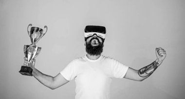 Sanal başarı kavramı. Şampiyonluğa ulaştı, Vr gözlüklü elinde altın kadehi tutun. Vr bardaklarda sakallı adam kazanan, gri arka plan var. Hipster mutlu yüz üzerinde sanal şampiyonluğa
