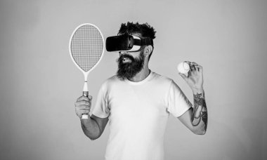 Vr gözlüklü play tenis raket ve top ile. Vr bardaklarda sakallı adam play tenis, gri arka plan. Sanal spor kavram. Gülümseyen yüzü üzerinde yenilikçi spor oyunları için modern teknolojisini kullanıyor