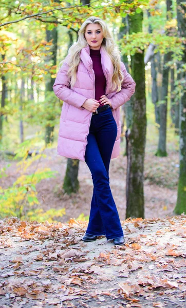 Chica rubia de moda caminar en el parque. Chaquetas que todos deberían tener. Los mejores abrigos hinchables para comprar. Cómo rockear chaqueta hinchable como estrella. Concepto de moda hinchable. El traje demuestra que el abrigo hinchable puede verse elegante —  Fotos de Stock