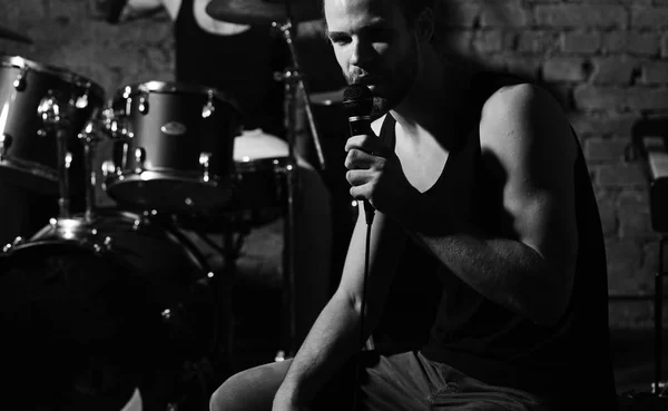 Guy near scene holds microphone and sings. — Stock Photo, Image