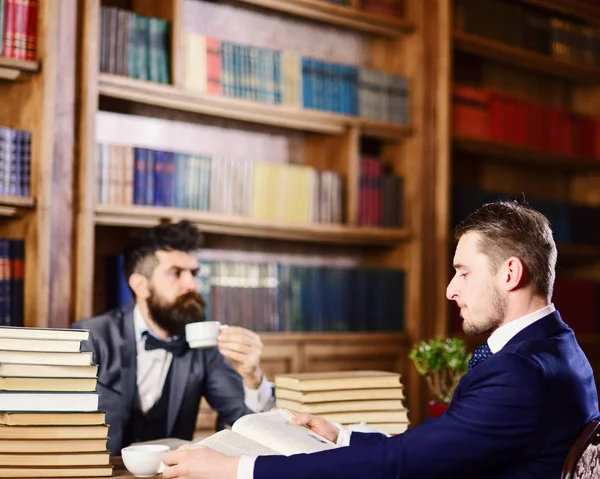 Мужчины с занятыми лицами читают книги, учатся и пьют чай . — стоковое фото