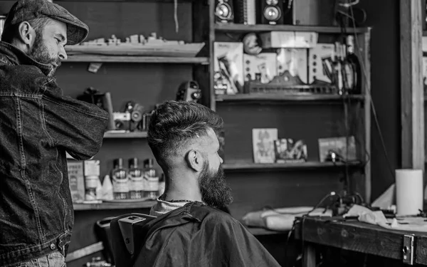 Client et maître professionnel vérifiant résultat ou coupe de cheveux. Le client Hipster a une nouvelle coupe de cheveux. Barbier avec homme barbu regardant miroir, fond de salon de coiffure. Concept de coupe de cheveux. coiffeur fini coiffage — Photo