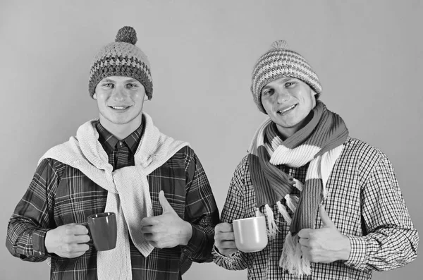 Les frères jumeaux dans des chapeaux chauds et des foulards tiennent des tasses — Photo