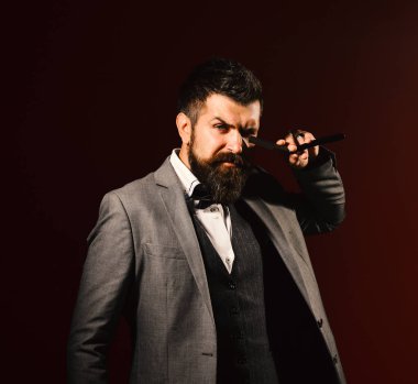 Uzun sakallı adam jileti gözüne yakın tutuyor..