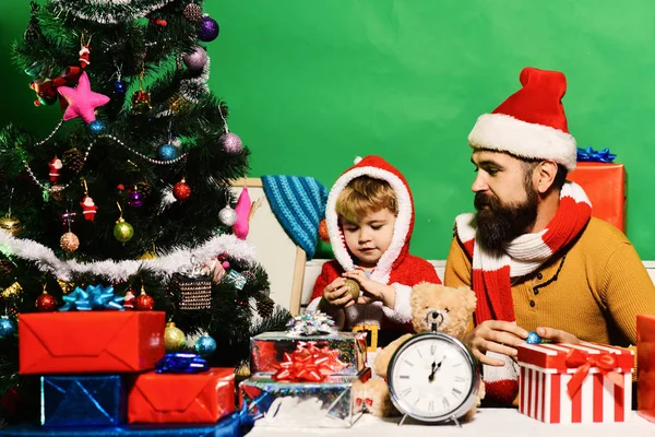 Babbo Natale e piccolo assistente tra scatole regalo vicino all'albero di Natale. — Foto Stock