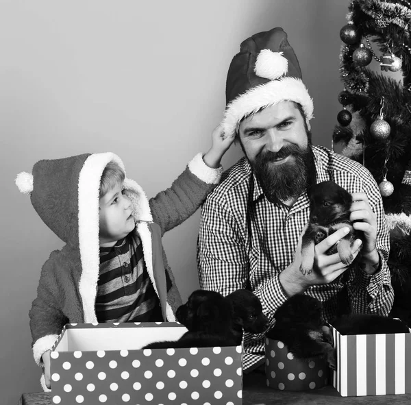 Vader en zoon met nieuwsgierige gezichten pakken cadeautjes uit — Stockfoto