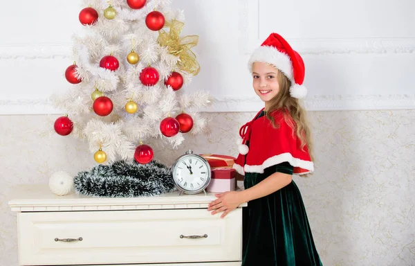 Last minute till midnight. New year countdown. Last minute new years eve plans that are actually lot of fun. Girl kid santa hat costume with clock counting time to new year. How much time before