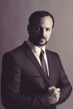 Sakallı ve ciddi yüzlü bir adam işleri yönetir..