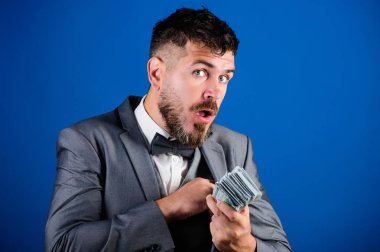 Kolay nakit krediler. İşadamı nakit para var. Zenginlik ve refah kavramı. Nakit kolay ve hızlı bir şekilde olsun. Nakit işlem iş. Resmi takım elbise tutun doları banknot yığını mavi arka plan