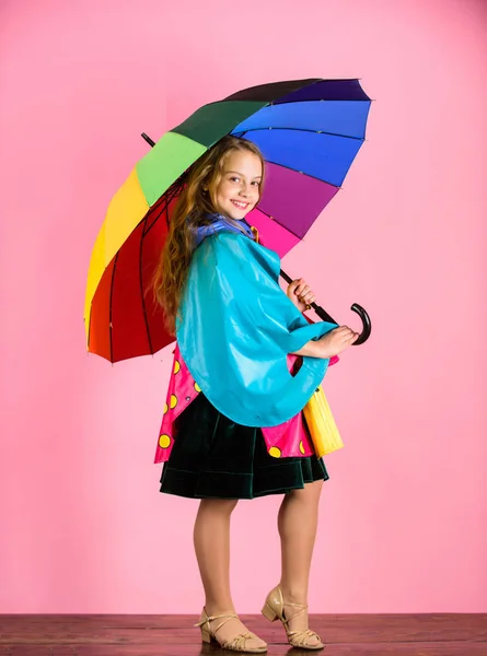 Vodotěsné příslušenství vyrábět. Šťastné dítě dívka drží Barevný deštník opotřebení Nepromokavý plášť. Vodotěsné příslušenství aby deštivý den, veselá a příjemná. Věří v její pád oděvy — Stock fotografie