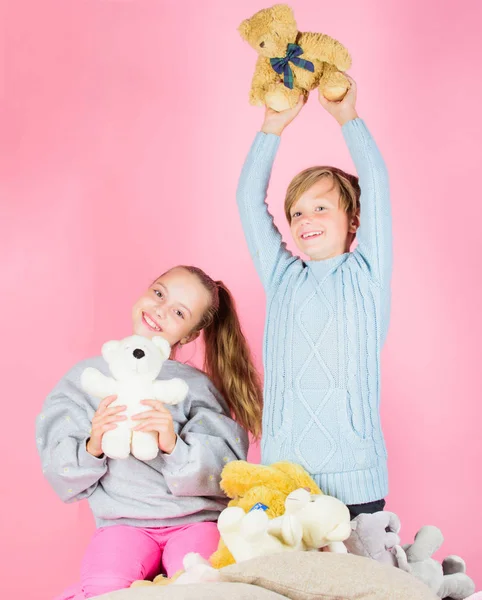 Irmãos brincalhão segurar ursinho pelúcia brinquedos. Menino e menina brincar com brinquedos macios ursinho de pelúcia no fundo rosa. Coleção de brinquedos de ursos. Ursos de pelúcia ajudam as crianças a lidar com emoções e limitar o estresse — Fotografia de Stock
