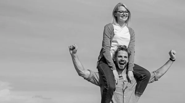 Soulmates enjoy freedom together. Couple in love enjoy freedom outdoor sunny day. Man carries girlfriend on shoulders, sky background. Couple happy date having fun together. Freedom concept