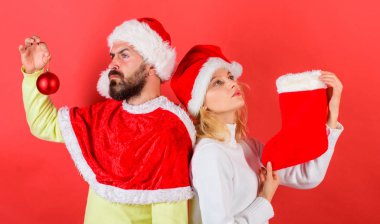 Noel kutlamaları kavramı. Noel çorap geleneği. Kadın ve santa şapka Noel kırmızı arka plan bekleyen sakallı adam. Çift Noel Noel Baba kostüm tutun çorap ve süsleme top