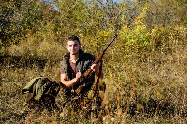 Jäger mit Gewehr auf der Suche nach Tier. Jäger khaki Kleidung bereit für die Jagd Natur Hintergrund. Jagdtrophäe. Mann lädt Jagdgewehr. Hobby und Freizeit der Jagd. Jagdgerätekonzept — Stockfoto