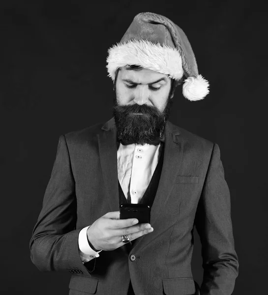 Man in smart suit and Santa hat on brown background