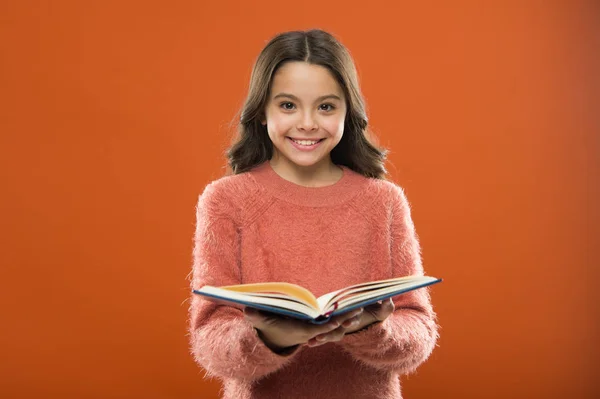 Mädchen halten Buch gelesen Geschichte auf orangefarbenem Hintergrund. Kinder lesen gerne Bücher. Buchhandelskonzept. wunderbare kostenlose Kinderbücher zum Lesen. Kinderliteratur. nützliche Informationen für sie — Stockfoto