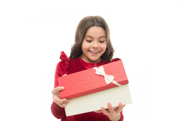 Pequeña linda chica recibió regalo de vacaciones. Lo que hay dentro. Los mejores juguetes y regalos de Navidad para niños. Niño niña en elegante vestido rizado peinado celebrar caja de regalo. Niño emocionado por desempacar su regalo —  Fotos de Stock