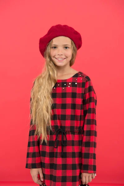 Mladý malá roztomilá dívka s dlouhými vlasy pózuje v hat červené pozadí. Módní baret příslušenství pro ženy. Jak nosit francouzský baret. Baret styl inspirace. Jak se nosí baret jako módní holka — Stock fotografie