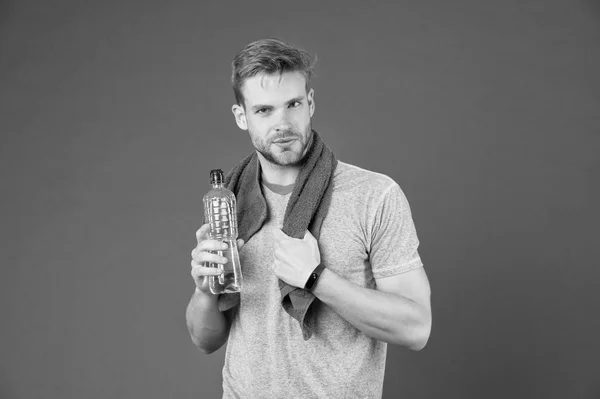 Mantente hidratado. Bebe algo de agua. Hombre atleta con toalla en los hombros sostiene la botella de agua. Hombre atleta ropa deportiva refrescante. Concepto de deporte y estilo de vida saludable. Atleta beber agua después del entrenamiento — Foto de Stock