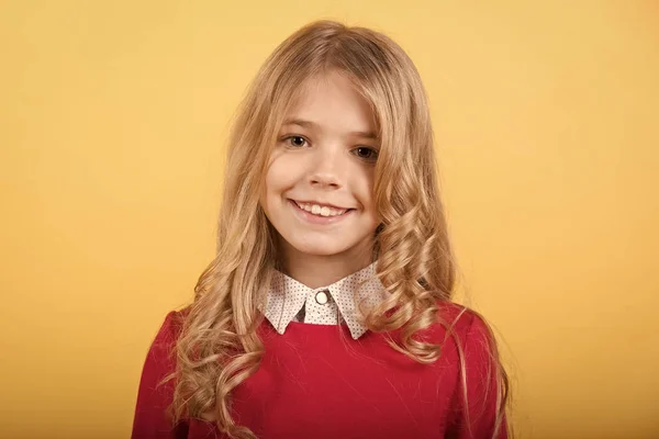 Niño con el pelo rubio rizado sobre fondo naranja — Foto de Stock