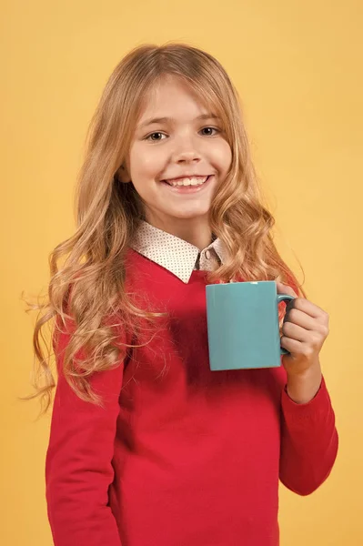 Criança sorriso com copo azul no fundo laranja — Fotografia de Stock