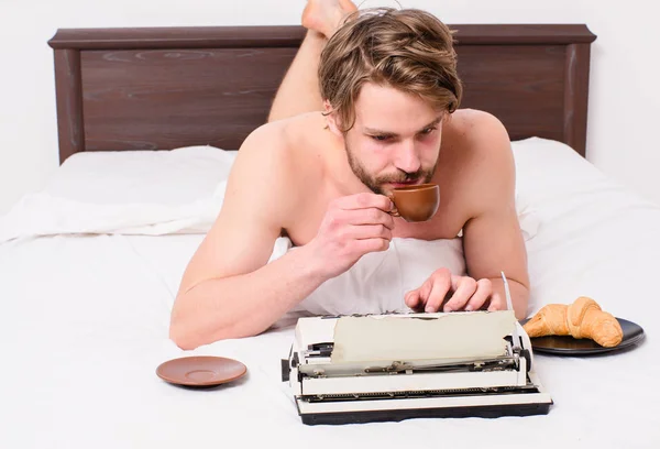 Uomo scrittore laici biancheria da letto libro di lavoro. Scrittore autore romantico usato vecchia macchina da scrivere stile. Autore che fa colazione a letto bere caffè. Ispirazione del mattino. Caffè che lo ispira a scrivere — Foto Stock