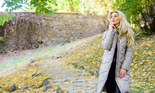 Girl fashionable blonde walk in autumn park. Woman wear warm grey jacket. Jacket everyone should have. Puffer fashion trend concept. Oversized jacket trend. Puffer jacket casual and comfortable style