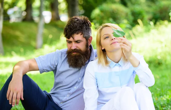 Néhány szakállas férfi és nő élvezze a természetet, miközben ül a rét zöld fű. Természet szépségét koncepció. Nő élvezni természet háttér pihenni. Tiszta természet. Pár zöld levél pihenni természetes környezet — Stock Fotó