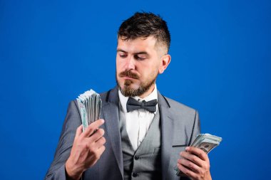 Nakit kolay ve hızlı bir şekilde olsun. Nakit işlem iş. Resmi takım elbise mavi arka plan doları banknot yığını tutun. Kolay nakit krediler. Zenginlik ve refah kavramı. İşadamı nakit para var.