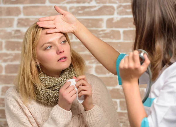 Recognize symptoms of cold. Remedies should help beat cold fast. Tips how to get rid of cold. Woman feels badly ill sneezing. Girl in scarf hold tissue while doctor examine her. Cold and flu remedies