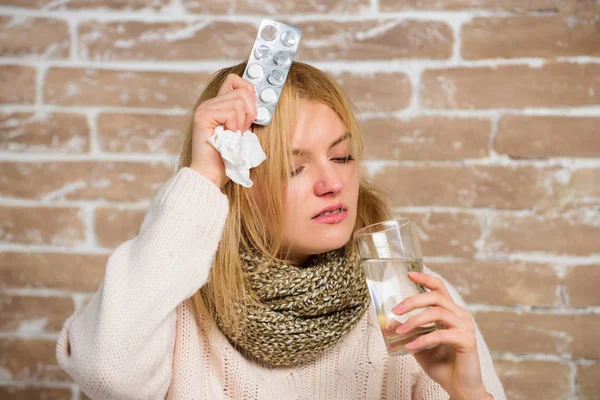 Cosa sapere sul raffreddore. La ragazza soffre di febbre e prendere medicine. Cefalea e febbre rimedi. Prendere farmaci per ridurre la febbre. Donna tousled capelli sciarpa tenere acqua di vetro e compresse blister — Foto Stock