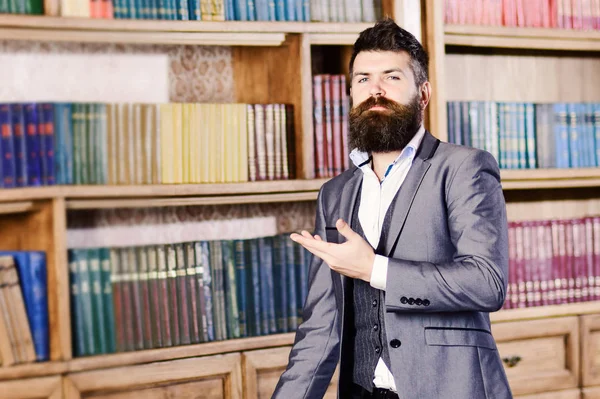 Розумний бізнесмен стоїть біля книжкової шафи в старовинному лібрарі — стокове фото