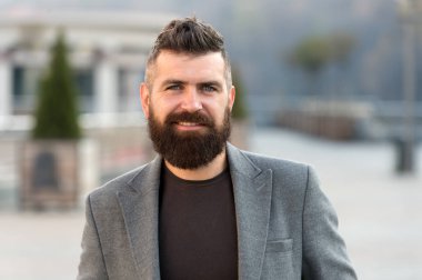 Sakallı adam. Sakallı moda adamı. Erkek berber bakımı. Sakallı, olgun bir hippi. Bıyıklı, vahşi, beyaz bir hippi. Gülümseyen adam dışarıda. Şık ve kendinden emin. sakal bakımı