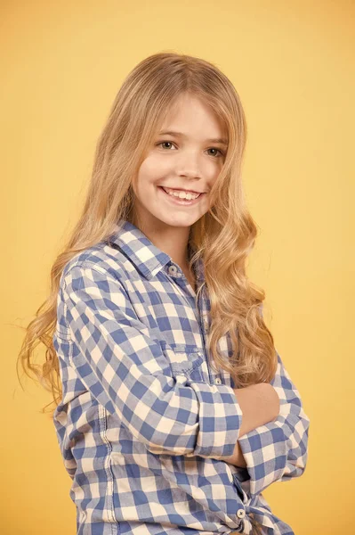 Enfant aux cheveux longs blonds en chemise à carreaux bleue sourire — Photo