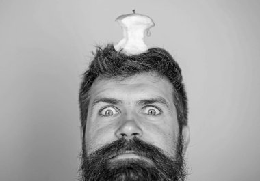 Hipster şok ile elma güdük hedef üzerinde kafa mavi arka plan, yüz kadar yakın. Kilo kaybı gol. Canlı hedef kavramı. Adam yakışıklı hipster uzun sakal neredeyse kafasına elma güdük hedef olarak yem.