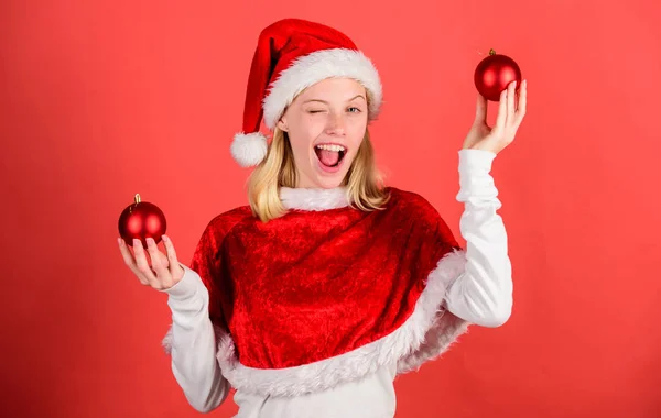 让我们玩得开心。女孩快乐穿圣诞老人服装庆祝圣诞节举行球装饰红色背景。最喜欢的时候一年圣诞节。圣诞快乐, 新年快乐。圣诞准备理念 — 图库照片