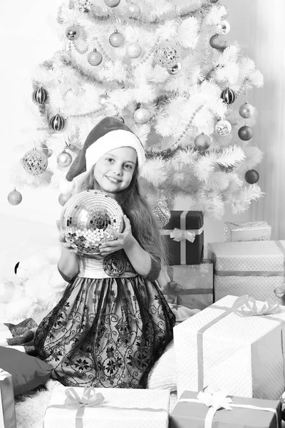 Um miúdo de chapéu de Pai Natal perto das caixas de presente. Pequena menina Santa — Fotografia de Stock
