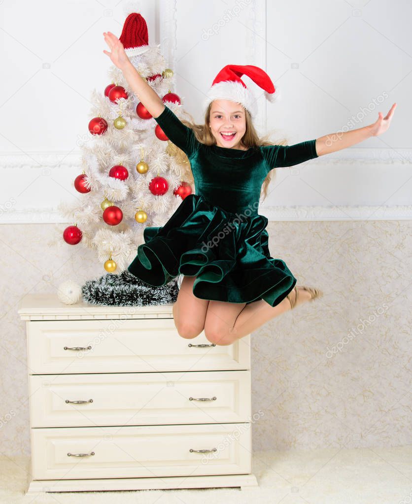 Girl excited about christmas jump mid air. Child emotional cant stop her feelings. Celebrate christmas concept. Girl in dress jumping. It is christmas. Day we have waited for all year finally here