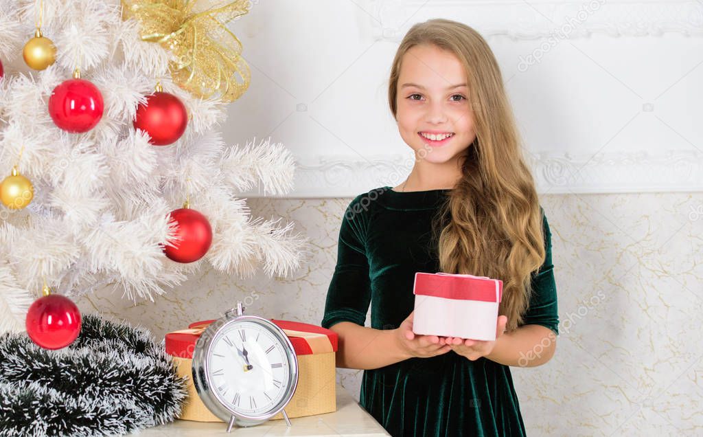 Child celebrate christmas at home. Favorite day of the year. Kid girl near christmas tree hold gift box. Time to open christmas gifts. Merry christmas concept. Dreams come true. Best for our kids
