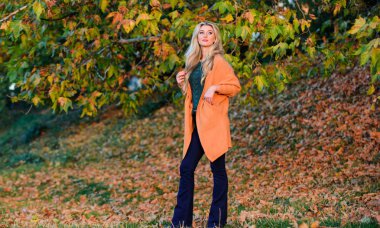 Hafta sonu için rahat kıyafet fikirler. Kadın yürüyüş günbatımı zamanı. Rahat rahat kıyafetler için geç düşmek. Rahat ve konforlu. Kız çok güzel sarışın defocused sıcak ve rahat kıyafet Sonbahar Doğa arka planda poz