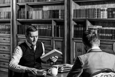 Akıllı elite ve eğitim kavramı. Antika kitap rafı ile genç erkek