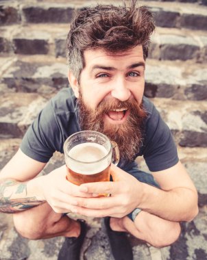 Fıçı bira ile dinlenme adam. Hippi neşeli yüz açık bira içiyor. Sakal ve bıyık tutar bira kıç, taş merdivenle arka plan oturur iken olan adam. Fıçı bira kavramı