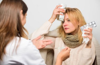 Doktor ile hasta tavsiye tedavi iletişim. Doktor hasta belirtileri hakkında sormak. Grip ve soğuk tedavi. Doktor tarafından muayene Fularlı Kız. Ateş ve grip ilaçları. Kadın Danışma doktor ile