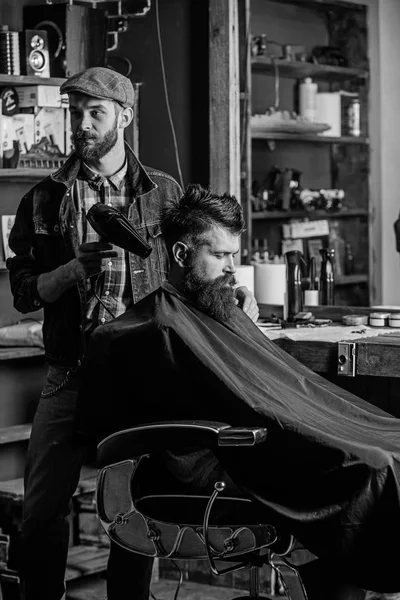 Kuaför saç kurutma makinesi ile saç modeli sakallı adam berber arka plan için çalışır. Hippi saç modeli almak istemci sakallı. İstemci saç kurutma saç kurutma makinesi ile berber. Hipster yaşam tarzı kavramı — Stok fotoğraf