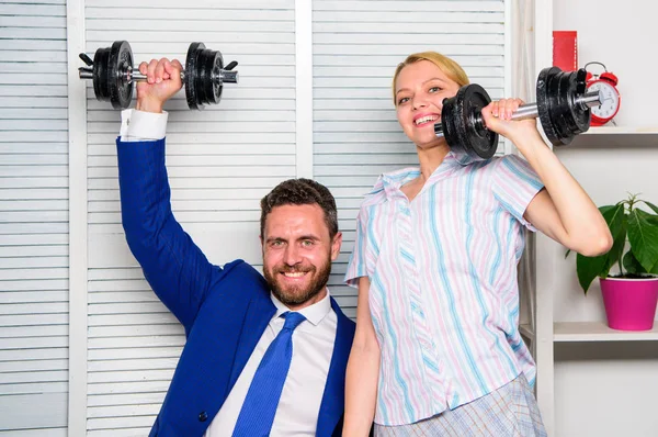 Boost sales with strong strategy. Good job concept. Boss businessman and office manager raise hand with dumbbells. Boost business team. Boost your skill. Man and woman raise heavy dumbbells